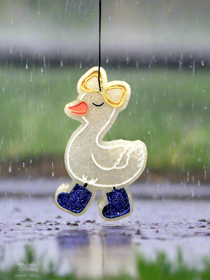 Decorative duck ornament with a bow and blue shoes on a light gray background