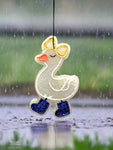 Decorative duck ornament with a bow and blue shoes on a light gray background